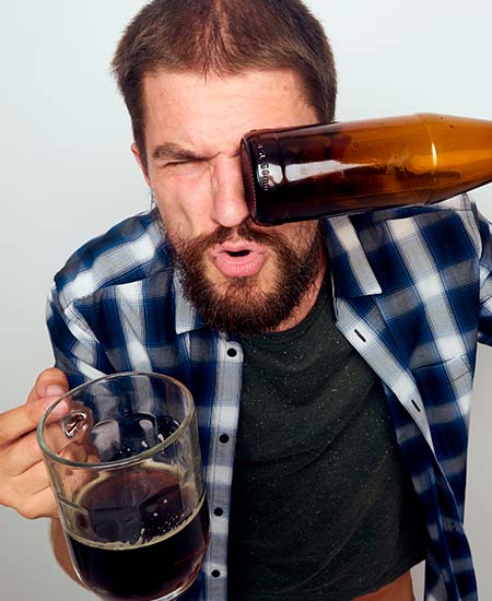 Мужчина с бутылкой и кружкой пива в руках